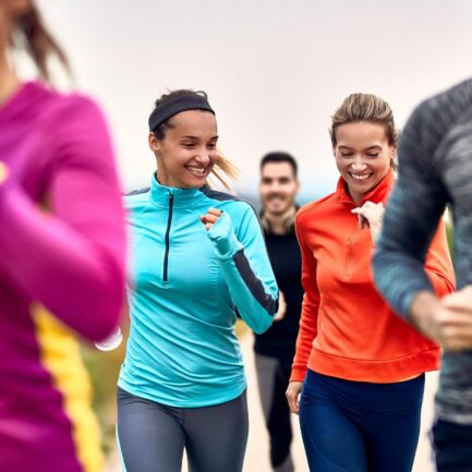 Happy athletic women having fun while jogging in a group