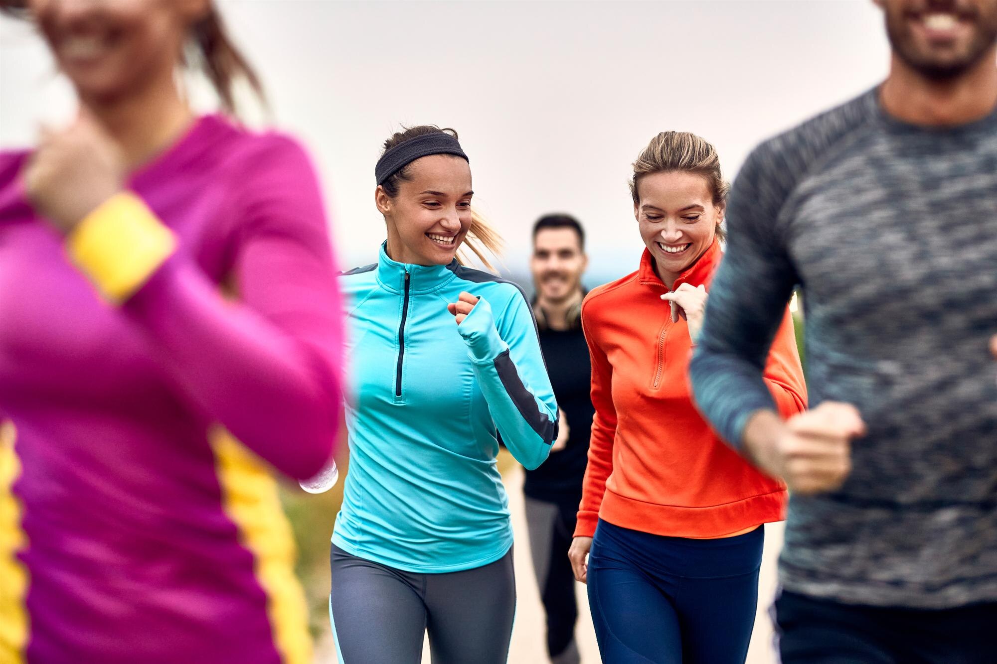 Happy athletic women having fun while jogging in a group